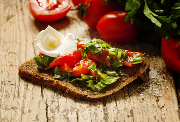 Fototapeta na wymiar sandwich with feta, tomatoes and herbs, selective focus