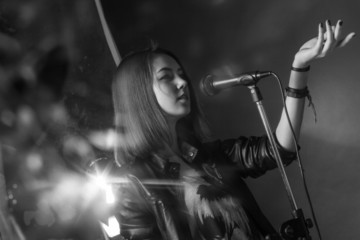 Fototapeta na wymiar girl singing into a microphone in a studio