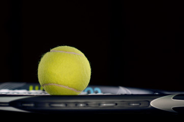 Tennis racket isolated on black background with tennis ball