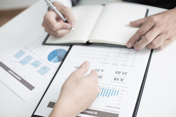 Two businessmen looking at report and having a discussion in off