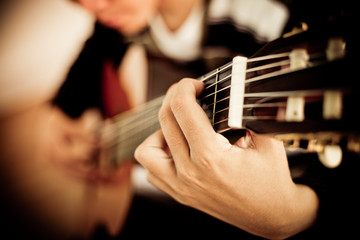 Obraz premium Practicing in playing guitar. Handsome young men playing guitar