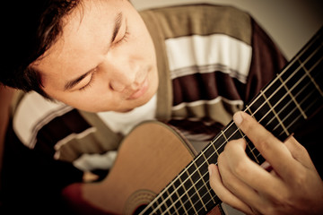Fototapeta premium Practicing in playing guitar. Handsome young men playing guitar