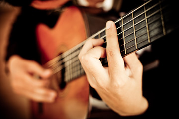 Fototapeta na wymiar Practicing in playing guitar. Handsome young men playing guitar