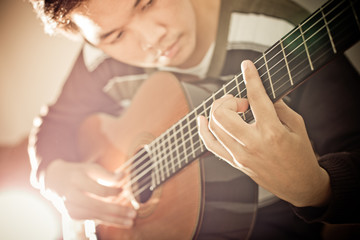 Fototapeta premium Practicing in playing guitar. Handsome young men playing guitar