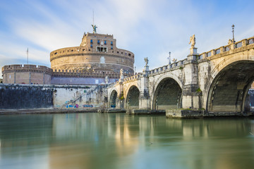 Obraz premium Saint Angel Castle and a bridge over the Tiber river in Rome.