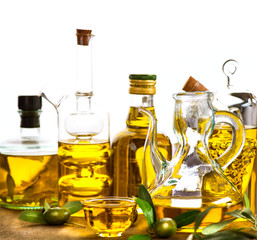 Olive oil. Bottles and jars of extra virgin olive oil over white