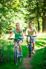 Young couple on bicycles in the park