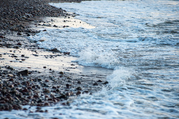 waves crushing over rocks in sunset