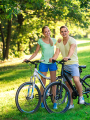 Smiling couple on bicycles outdoors