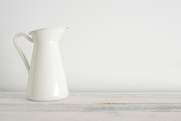 Old white vase on the white wooden shelf. White background.