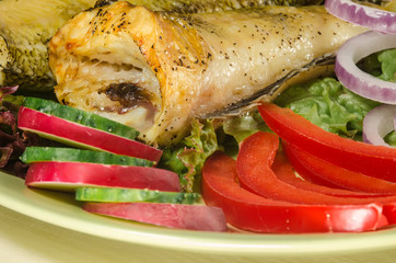 Baked shad with vegatables at dish close up
