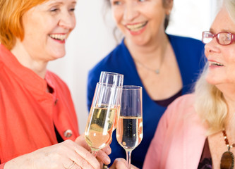 Glasses of White Wine Tossed by Happy Adult Ladies. Close up.