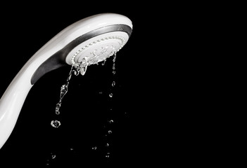 Obraz na płótnie Canvas Modern shower head with running water isolated on black backgr