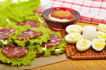 Smoked sausage with quail eggs and lettuc