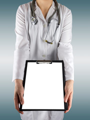 Female doctor's hand holding medical clipboard with blank sheet