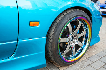  Car wheel on colorful metallic disc, closeup photo