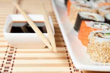 Sushi Assortment On White Dish over bamboo background.