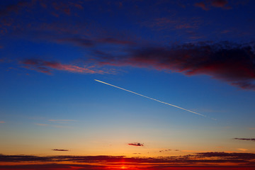 Airplane in the sky against a background of dawn.