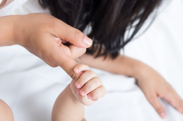 closeup shot of baby's hand holding her mother's finger