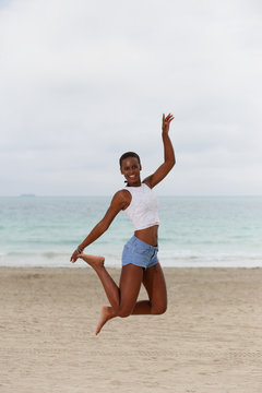 Woman jumping on the sand in Miami Beach