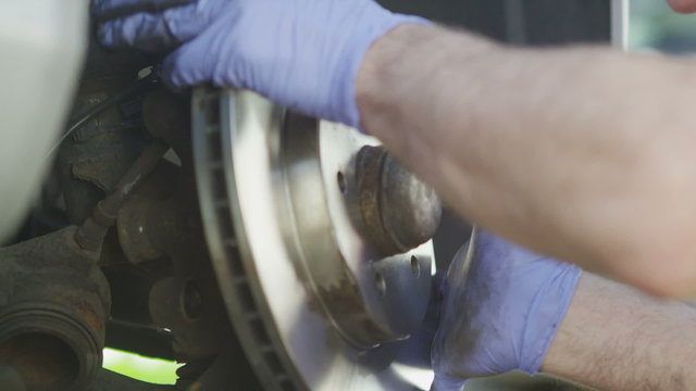 Car mechanic installing a new brake disc