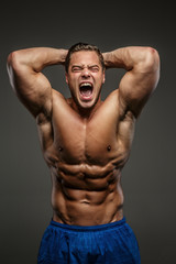 Fototapeta na wymiar Awesome muscular guy on grey background