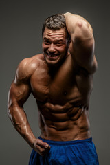 Fototapeta na wymiar Awesome muscular guy on grey background