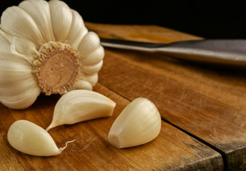 Garlic segments on a kitchen board with a knife