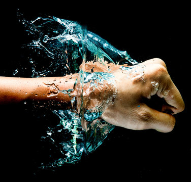 Fist punch into water with big splashes, on a black background