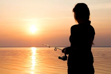 Papier Peint photo autocollant Pêcher silhouette d& 39 une fille sur la rive de la rivière avec une canne à pêche