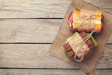 Two sandwiches with salad, ham, cheese and tomatoes