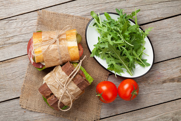 Two sandwiches with salad, ham, cheese and tomatoes