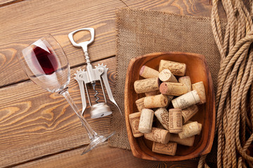 Red wine glass, corkscrew and bowl with corks
