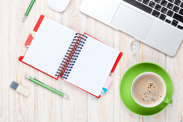 Office desk table with computer, supplies and coffee cup