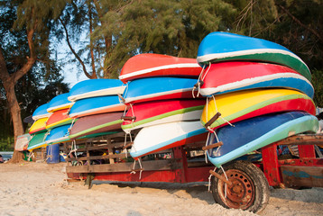Fototapeta na wymiar Colorful plastic boats on a rack ashore