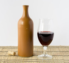 Ceramic bottle and a glass of red wine