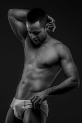 Fototapeta premium Man in panties posing on gray background