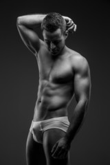 Fototapeta premium Man in panties posing on gray background