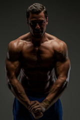 Fototapeta na wymiar Awesome muscular guy posing in studio