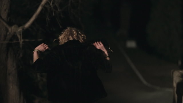 Beautifully dressed woman runs away from someone in the park at