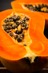 Two haft of fresh papaya with sackbak on wooden background