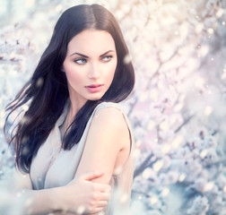Spring fashion girl outdoor portrait in blooming trees