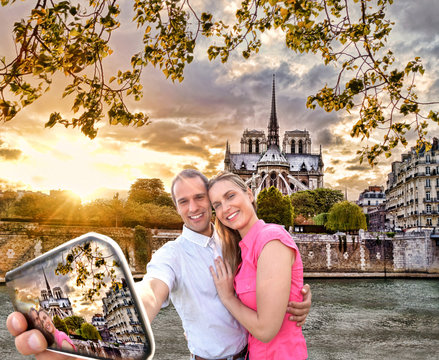 Couple Taking Selfie by Notre Dame cathedral in Paris, France