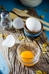 Still life broken white eggs and egg yolk on a wooden rustic bac