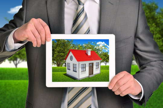 Estate agent showing photo with house on tablet screen holding