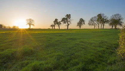 Fototapeta premium Sunset over over a hill under a blue sky