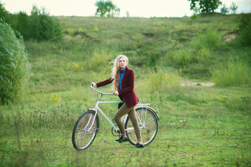 Fototapeta premium The beautiful blonde on a bicycle in the spring
