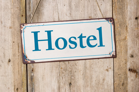 Altes Blechschild vor rustikaler Holzwand - Hostel