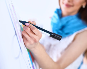 Young woman drawing on wihteboard with white copyspace