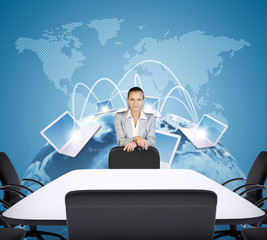 Businesswoman standing behind the chair and looking at camera